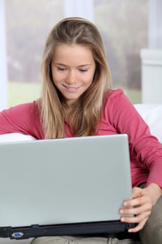 Blond teenager connected on internet at home