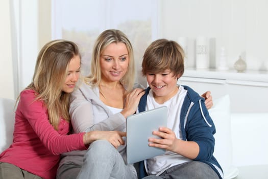 Family having fun at home using electronic tablet