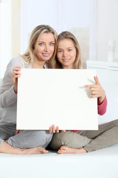 Woman and young girl holding whiteboard