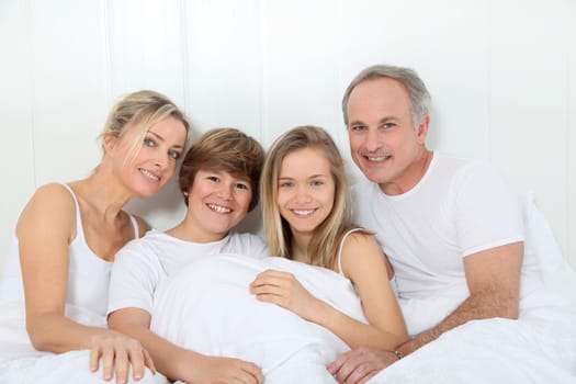 Portrait of happy family in bed in the morning