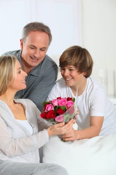 Son offering bunch flowers on mother's birthday