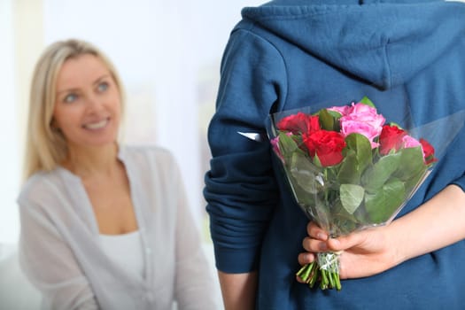 Closeup of bunch flowers hidden behind boy's back
