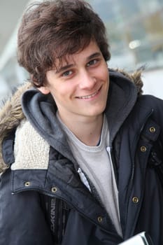 Portrait of teenage boy in front of school building