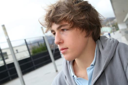 Portrait of teenage boy in front of school building