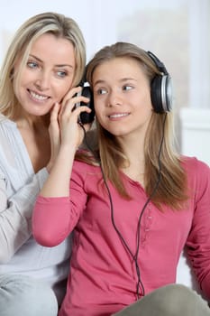 Mother and daughter listening to music whit headphones