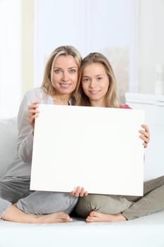 Woman and young girl holding whiteboard