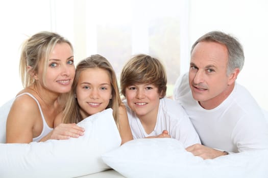 Portrait of happy family in bed in the morning