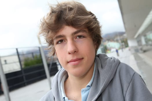 Portrait of teenage boy in front of school building