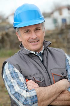 Portrait of smiling engineer with blue security helmet