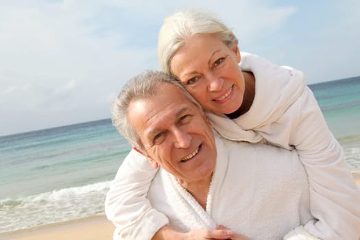 Senior couple in bathrobe at the beach