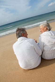 Senior couple in bathrobe at the beach