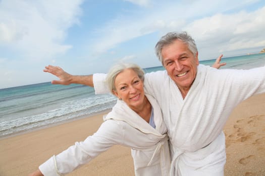 Senior couple in bathrobe at the beach
