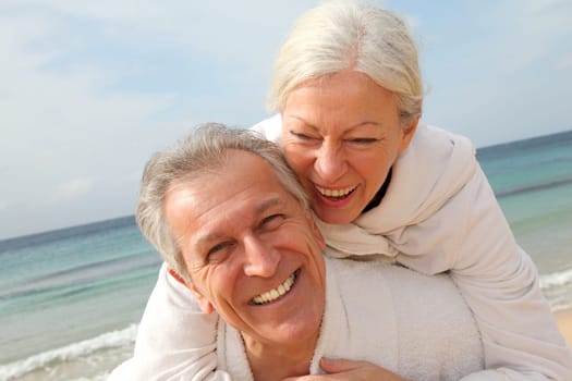 Senior couple in bathrobe at the beach