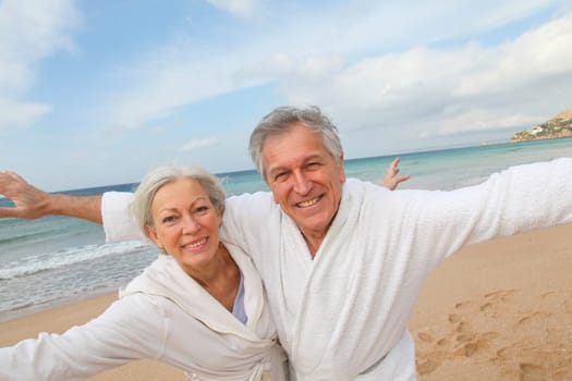 Senior couple in bathrobe at the beach