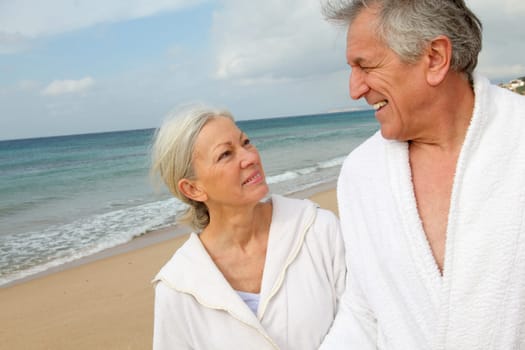 Senior couple in bathrobe at the beach