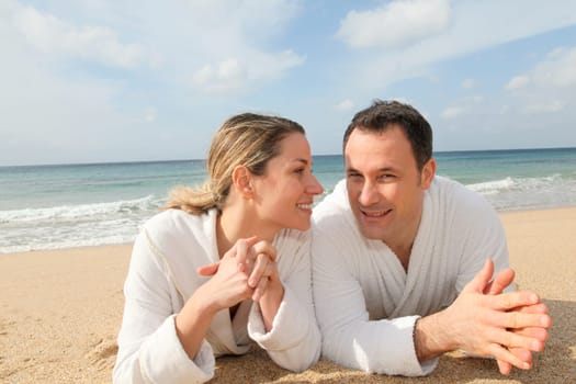 Couple relaxing in bathrobe at the beach