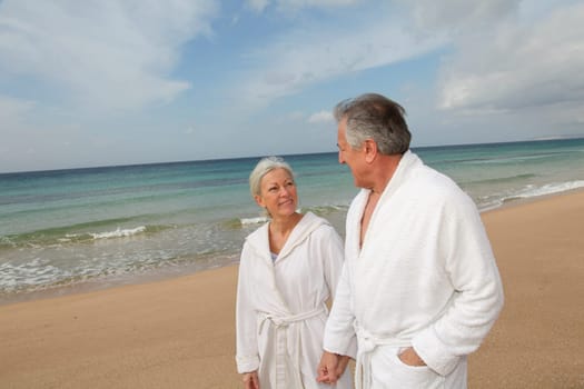 Senior couple in bathrobe at the beach