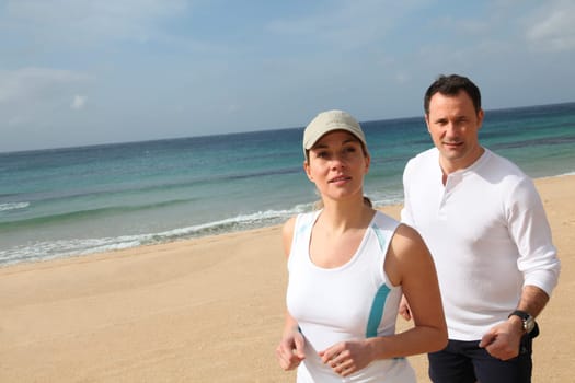Couple running on a sandy beach