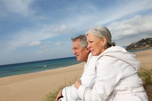Senior couple in bathrobe at the beach