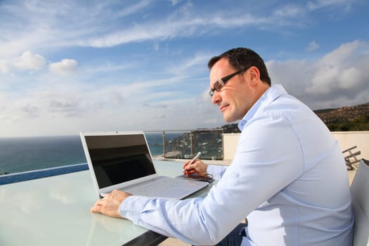 Man working in front of the sea during vacation time