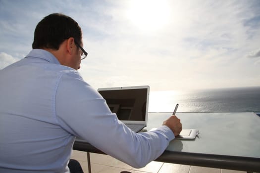 Man working in front of the sea during vacation time