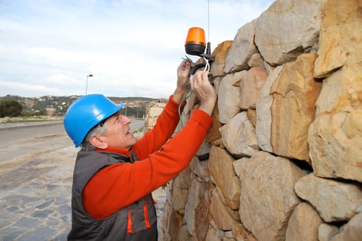 Worker with security helmet installing gate system