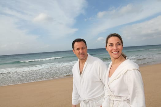 Couple relaxing in bathrobe at the beach