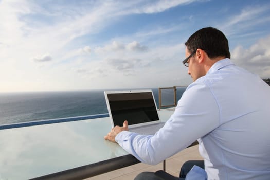 Man working in front of the sea during vacation time