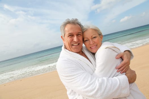 Senior couple in bathrobe at the beach