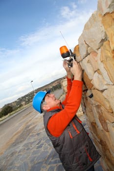 Worker with security helmet installing gate system