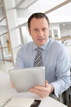 Businessman sitting in the office with electronic tab