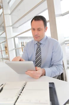 Businessman sitting in the office with electronic tab