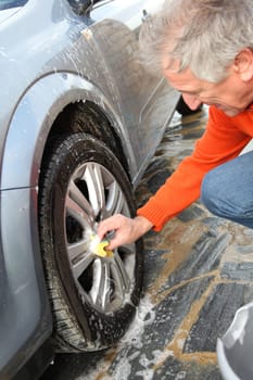 Senior man washing his car
