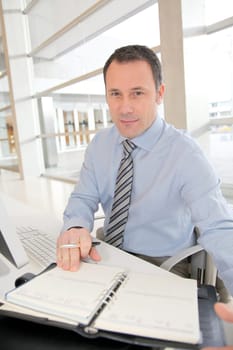 Portrait of salesman writing on agenda