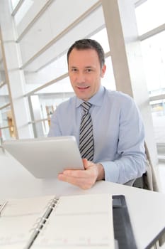 Businessman sitting in the office with electronic tab