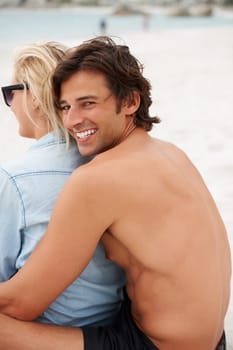Couple, beach sand and sitting hug for holiday vacation, sunshine lovers or sea salt hair. Man, portrait and woman relax for partnership connection or ocean view, romantic or summer tropical travel.