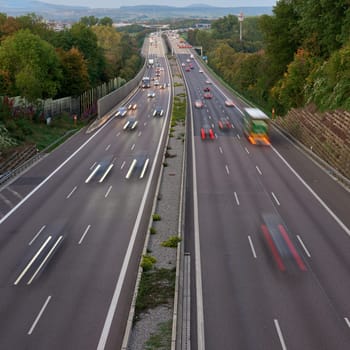 Night lights from car headlights on roundabout in night city. Traces of headlights on the road at night, long exposure. Drone aerial shot. Panoramic aerial view of illuminated road overpass and road junction. traffic lights traces cars top view road top view