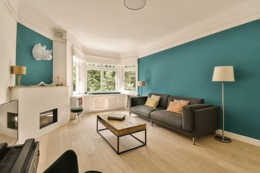 a living room with teal blue walls and white trim on the walls, wood flooring and fireplaces