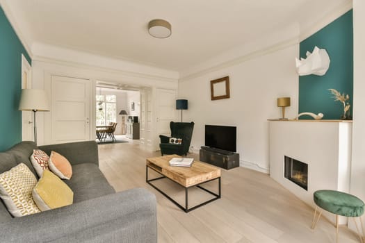 a living room with blue walls and white trim on the walls, wood flooring and grey sofas in front