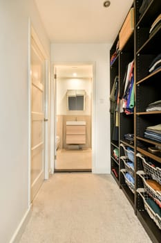 a walk - in closet with lots of clothes on the shelfs and shelves next to the door is open