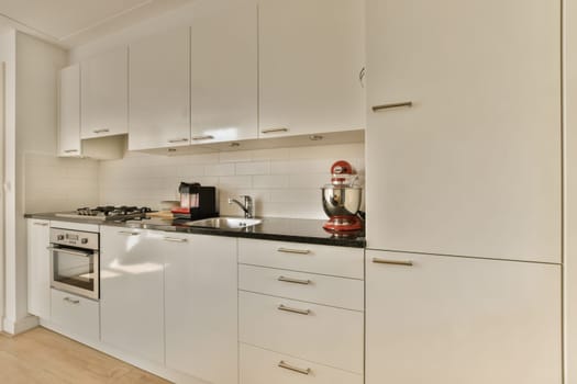 a kitchen with white cabinets and black counter tops on the counters in front of the sink is an appliance