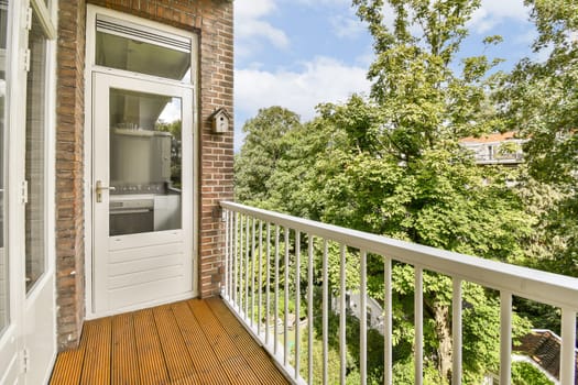 a balcony with an open door and trees in the background on a bright sunny day, taken from above it