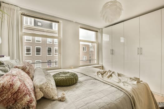 a bedroom with a bed, pillows and other items on the floor in front of the window that looks out onto the street