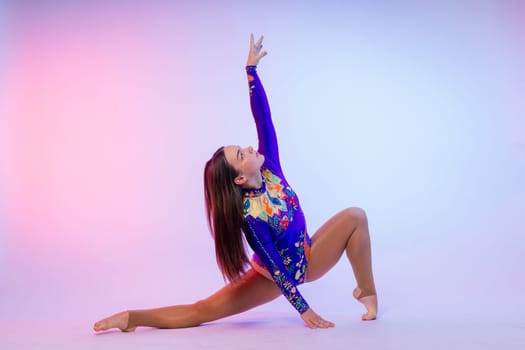 Sportive exercises, standing and stretching the hands. Beautiful muscular woman in indoors studio.