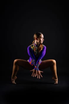 Sportive exercises, standing and stretching the hands. Beautiful muscular woman in indoors studio.