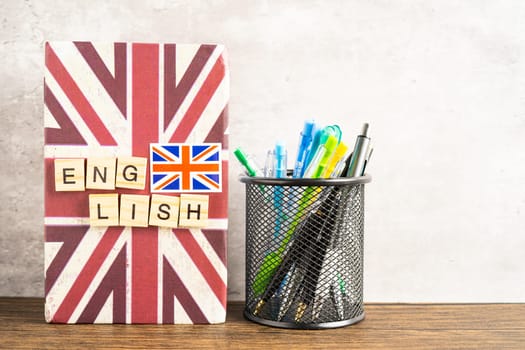 Word English on book with United Kingdom flag, learning English language courses concept.