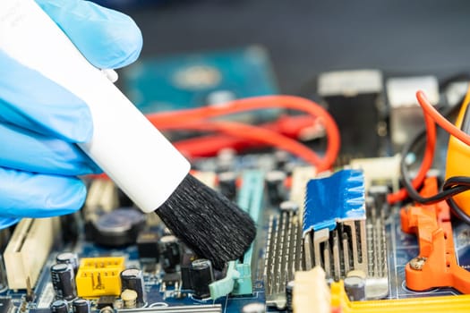 Asian technician repair and cleaning dirty micro circuit main board of smartphone electronic technology with brush, hardware, mobile phone, upgrade concept.