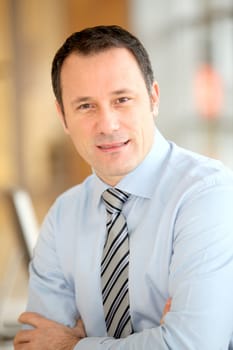 Portrait of smiling businessman with arms crossed