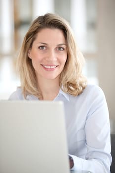 Smiling office worker in front of laptop computer