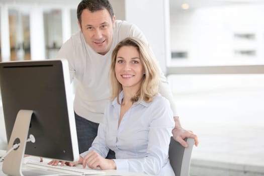 Office workers in front of desktop computer